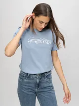 Remera de Tommy Hilfiger de corte regular, color celeste, con cuello redondo, mangas cortas y detalle de logo y diseño floral bordado en el pecho.