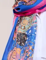 Pashmina rectangular de satén con acabado brillante y caída fluida, con un diseño de estampa gráfica multicolor en toda la superficie y terminaciones con dobladillo fino.