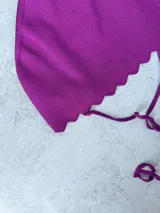 Top de hilo negro tejido de punto, modelo halter, con tiras para atar en la nuca y en la espalda.