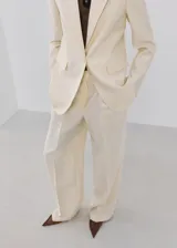 Pantalón wide leg de tiro bajo color beige, con trabillas y dos bolsillos laterales.