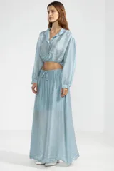 Falda larga hasta el tobillo color celeste, confeccionada en tejido arrugado liviano con cintura elástica.