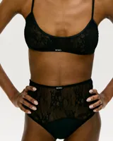 Top de lencería tipo bralette confeccionado en encaje negro, con breteles finos ajustables y diseño de escote redondo.