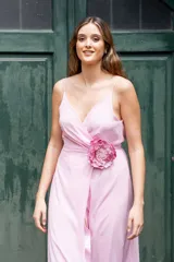 Vestido largo de crep rosa lila, con escote en V cruzado y detalle de aplicación floral en la cintura.