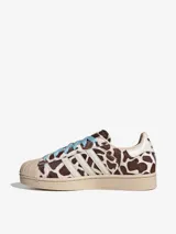 Championes Adidas Superstar II con diseño de estampado animal print tipo vaca, puntera de goma clásica, tres tiras laterales blancas y cordones en color celeste.
