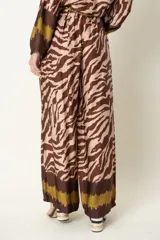 Pantalón palazzo de viscosa con estampado de cebra en tonos azul marino y beige, con detalles en marrón en la cintura y el ruedo.