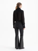 Jeans bootcut negros de denim elastizado con botamanga ancha confeccionada en cuero negro al tono.