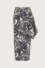 Pareo largo de diseño envolvente con nudo lateral, confeccionado en tejido fresco con estampado de motivos orgánicos en tonos verde y violeta sobre fondo blanco.