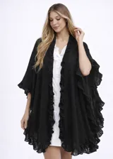 Ruana negra de tejido liviano, con diseño abierto y terminaciones con volados amplios en todo el contorno.