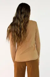 Remera de manga larga en color blanco, con cuello redondo y detalle de costura en el borde del escote. Confeccionada en tejido de algodón, presenta un corte recto y básico.