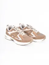 Zapatillas deportivas de estilo urbano en tonos beige y marrón, confeccionadas en una combinación de malla y gamuza. Presentan cordones al tono, suela gruesa de goma blanca y diseño con paneles superpuestos.