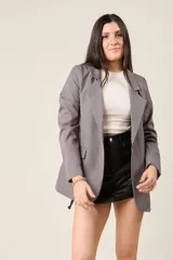 Blazer negro de corte sastre, con solapas de muesca, cierre frontal con un botón y bolsillos delanteros con solapa.