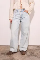 Pantalón de jean con corte wide leg y tiro medio, en color celeste claro con efecto lavado. Presenta diseño de cinco bolsillos y cierre frontal con botón y cremallera.