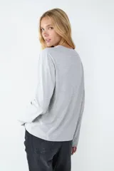 Remera básica de manga larga color gris melange, con cuello redondo y corte regular. Confeccionada en tejido de punto liso de algodón.