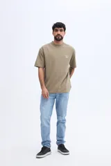 Remera de manga corta color verde militar con textura sutil y pequeña estampa discreta en el pecho.
