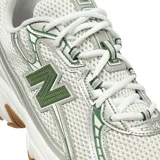 Championes New Balance modelo 740, con diseño técnico en malla blanca y superposiciones plateadas con detalles en verde. Cuenta con entresuela blanca con tecnología ABZORB y suela de goma color caramelo.