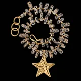 Collar de piedras jaspe dálmata de formas irregulares con detalles dorados, cierre de gancho y argollas de alargue, con un gran dije colgante en forma de estrella de bronce con textura.