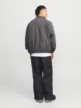 Campera bomber liviana color gris oscuro, con cierre frontal de cremallera, cuello baseball, bolsillos funcionales y puños elásticos acanalados.