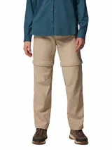 Pantalón Columbia de trekking convertible en bermuda, modelo Leslie Convert Pant Omni-Shade, color beige, con perneras desmontables mediante cremallera, bolsillos laterales y tecnología de protección solar.