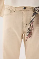 Pantalón de lino color beige, de corte recto y tiro medio, con bolsillos laterales y detalles de costuras visibles.
