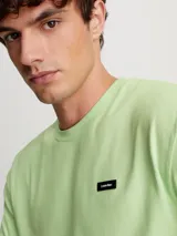 Remera de punto de algodón regenerativo color verde menta, de corte regular, cuello redondo y mangas cortas. Incluye una lengüeta con el logo de Calvin Klein en el pecho.