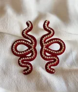 Aros colgantes con forma de serpiente blanca delineada con strass plateado.