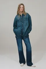 Jean ancho de tiro alto confeccionado en denim de algodón con ligero stretch, de color azul oscuro con efecto deslavado y pliegues frontales.