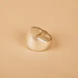Anillo de diseño minimalista fabricado en plata 925, con una superficie lisa, pulida y de forma ligeramente irregular.