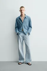 Jeans flare fit confeccionados en denim de algodón de tejido rígido, color celeste claro. Presentan diseño de cintura efecto revés, cinco bolsillos, tiro medio y cierre frontal con cremallera y botón.