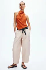 Pantalón cargo de color beige, con perneras estilo globo, cintura elástica y bolsillos laterales de parche.