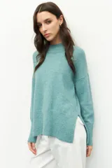 Polera de punto color negro, con cuello alto y mangas largas de corte holgado.