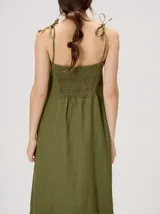 Vestido largo de algodón denim con diseño de rayas verticales en color azul marino y beige. Cuenta con tirantes finos ajustables con lazos en los hombros, escote recto y corte suelto con un volante en el bajo.