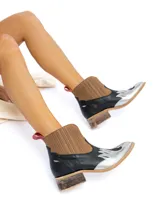 Botas tejanas de cuero vacuno con elásticos laterales, taco bajo y diseño bitono: puntera plateada con apliques, cuerpo negro y caña marrón acanalada.