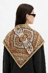 Pañuelo cuadrado de seda con estampado paisley en tonos tierra, naranja y crema, con borde liso en color beige.