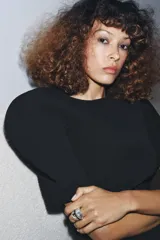 Anillo de diseño orgánico y asimétrico, con base ancha plateada envejecida y una sección superior dorada. Presenta una banda central oscura engastada con pequeños cristales transparentes y un cristal más grande en el extremo superior.