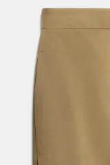 Pantalón de tiro medio confeccionado en mezcla de lyocell, con diseño de pliegues delanteros superpuestos y bolsillos laterales ocultos en costura.