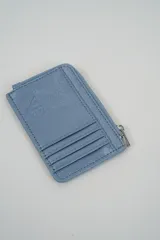 Billetera pequeña color negro con cierre de cremallera plateado y apliques de tachas metálicas redondas en la parte frontal.