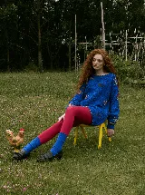 Buzo tejido a mano en lana merino, de corte oversized y diseño en bloques. Presenta un vibrante color rojo con detalles bordados a mano en forma de flores y texturas en relieve.