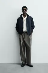 Cazadora azul marino de corte regular fit, confeccionada en tejido técnico repelente al agua. Presenta cuello subido, manga larga, bolsillos de vivo en cadera, bolsillo interior y acabados en rib en puños y bajo. Cierre frontal de cremallera oculta por solapa con botones a presión.