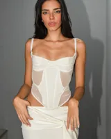 Corset blanco con breteles finos y paneles de tul transparente.