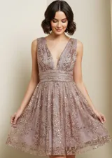 Vestido corto de fiesta con escote en V profundo, sin mangas y falda con vuelo. Está confeccionado en una base de tul con bordados florales y aplicaciones de lentejuelas y glitter en tonos rosados y dorados.