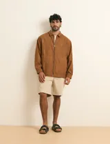 Campera de napa ecológica de color marrón, con cierre frontal metálico, bolsillos laterales y cuello camisero.