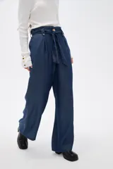 Pantalon de lyocell azul oscuro, de corte wide leg y tiro alto. Presenta cintura estilo paper bag con lazo ajustable del mismo tejido y cierre frontal con botón.