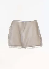Falda corta de tiro medio con diseño recto y doble capa, confeccionada en tejido bordado con lentejuelas brillantes. Cuenta con cierre de cremallera lateral.