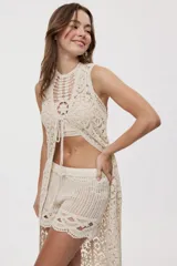 Short de crochet color beige, con calce relajado y tiro medio, diseño de tejido calado con detalles artesanales y terminaciones onduladas en el ruedo.