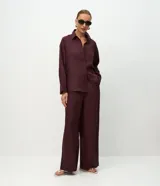 Pantalón recto de lino color bordó, con cintura elástica y trabillas para cinturón. Presenta un diseño holgado y fluido, ideal para un look sofisticado y cómodo.