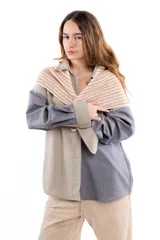 Chal pañuelo de formato triangular tejido a mano en lana merino y seda, con diseño de rayas horizontales en tonos beige y blanco.