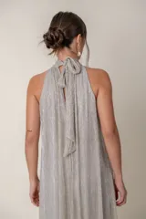 Mono plateado de lurex, corte ancho, con cuello halter y lazo.