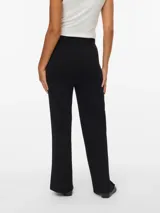 Pantalón tejido de punto con tiro medio y corte holgado. Presenta cintura elastizada con cordón ajustable y textura acanalada fina, ofreciendo una caída fluida y cómoda.