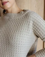 Sweater de punto color verde claro con textura tipo waffle, cuello redondo y mangas 3/4.