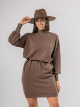 Vestido tipo polerón de tejido de punto color borgoña, con cuello alto, mangas largas con puños ajustados y corte recto. Incluye un cinturón del mismo material con una hebilla decorativa de flor con cristales.